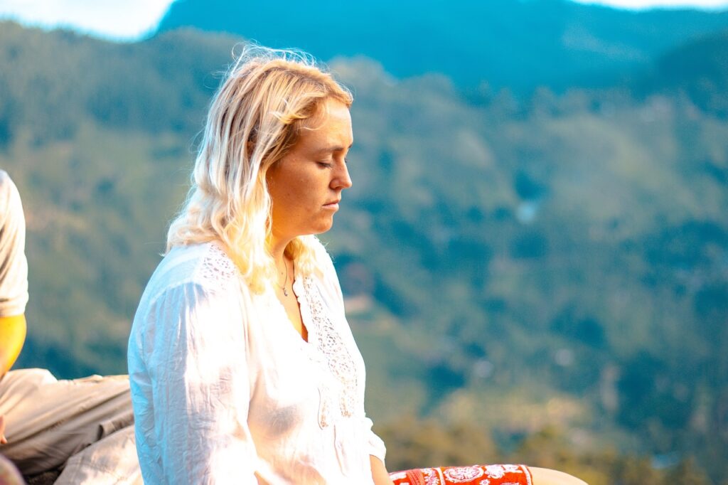 Woman meditating outdoors, ideal for comparing luxury wellness retreats in Peru's serene landscapes.